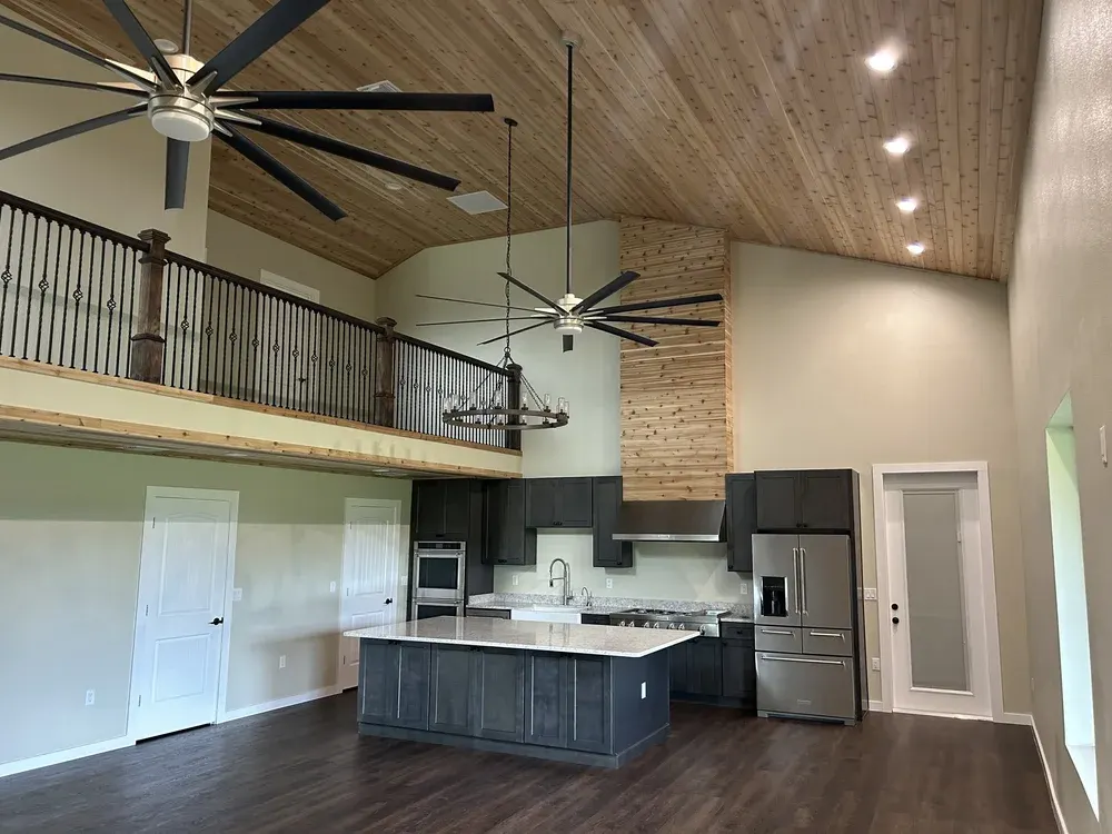 Open-concept barndominium interior in Florida with loft, wood ceiling and full kitchen &mdash; appraises like a site-built home